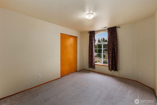 unfurnished room with baseboards, carpet flooring, and visible vents