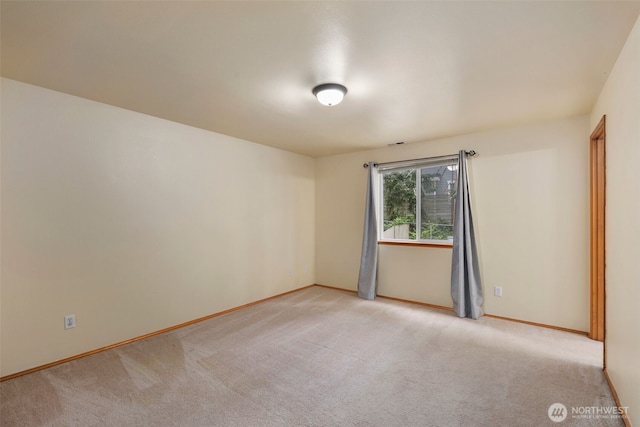 empty room with baseboards and light colored carpet