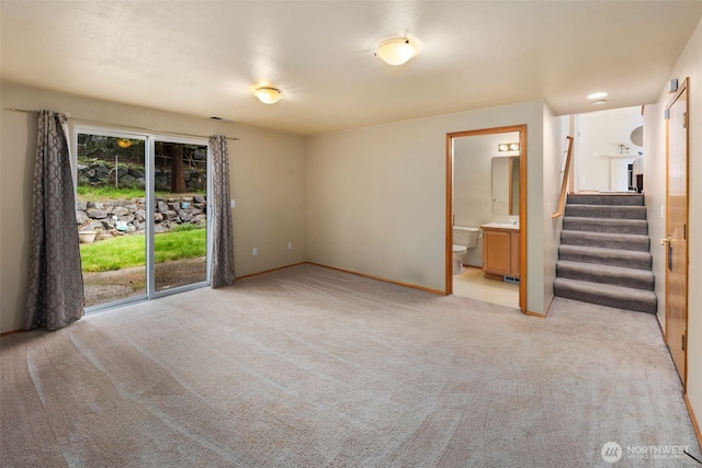 empty room with stairs and light colored carpet