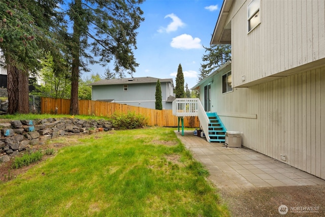 view of yard with a patio, fence, and stairs