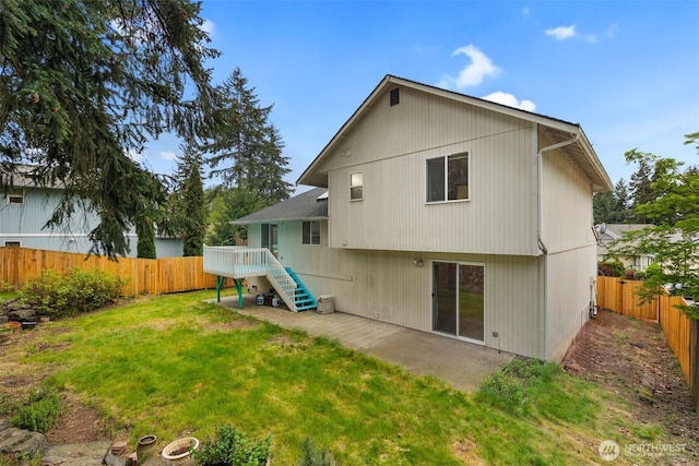 rear view of house with a wooden deck, a fenced backyard, a patio area, a lawn, and stairway