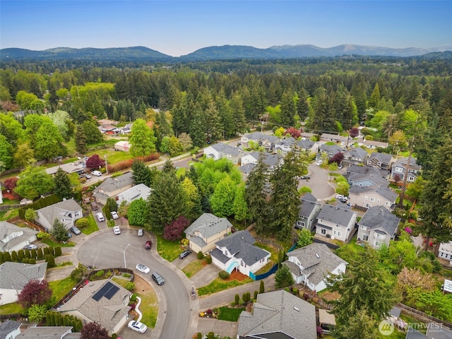bird's eye view featuring a residential view, a wooded view, and a mountain view
