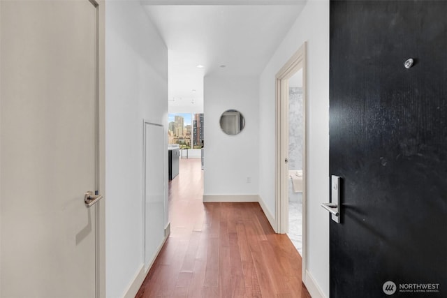 hallway featuring wood finished floors and baseboards