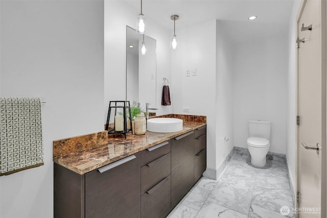 bathroom featuring marble finish flooring, toilet, vanity, recessed lighting, and baseboards