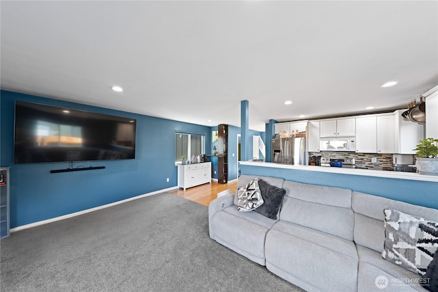 living room with recessed lighting, baseboards, and light carpet