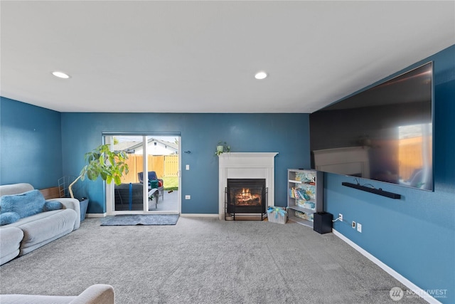 carpeted living room featuring baseboards, a glass covered fireplace, and recessed lighting