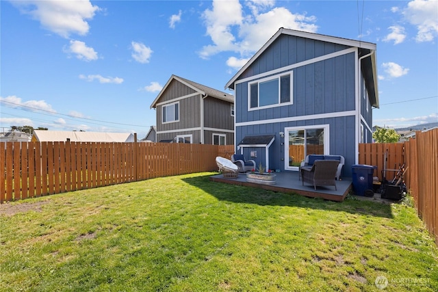 back of property featuring a lawn, a fenced backyard, and a wooden deck