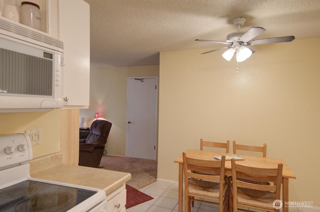 6110 24th Ave NW Unit 203, Seattle, WA 98107 - kitchen featuring electric range, white microwave, ceiling fan, a textured ceiling, and light carpet