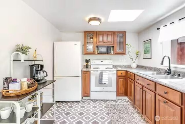 4027 S 275th Pl, Auburn, WA 98001 - kitchen featuring white appliances, a sink, brown cabinetry, a skylight, and light countertops