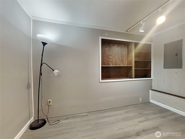 interior space featuring baseboards, wood finished floors, and electric panel