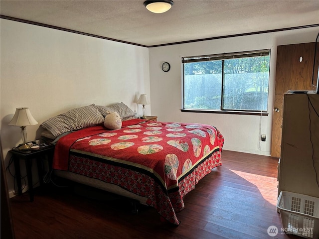 bedroom with wood finished floors and a textured ceiling