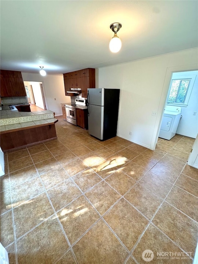 1145 Blaine St, Port Townsend, WA 98368 - kitchen with tile patterned flooring, washer / clothes dryer, appliances with stainless steel finishes, and tile counters