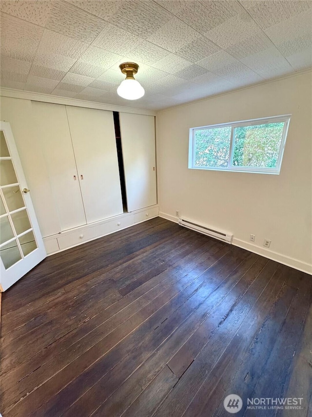 1145 Blaine St, Port Townsend, WA 98368 - unfurnished bedroom featuring a baseboard radiator, baseboards, a closet, and dark wood-type flooring
