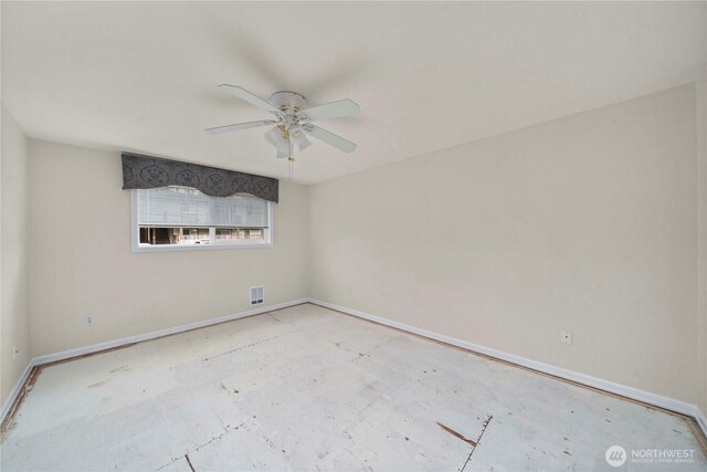 empty room with baseboards, ceiling fan, and visible vents