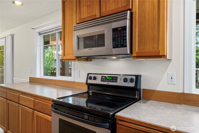 kitchen with light countertops, appliances with stainless steel finishes, and brown cabinetry