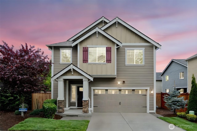 craftsman inspired home with fence, an attached garage, stone siding, board and batten siding, and concrete driveway
