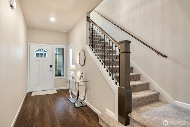 foyer with baseboards, wood finished floors, and stairway