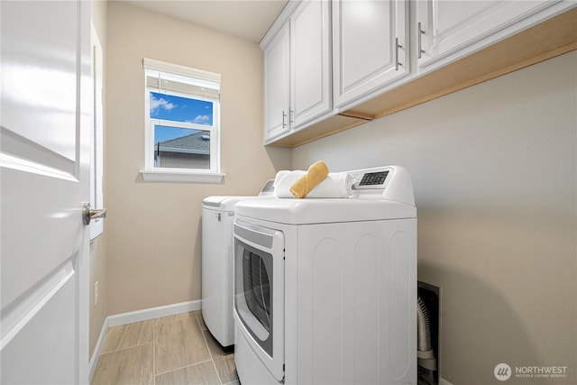 laundry area with washer and dryer, baseboards, and cabinet space