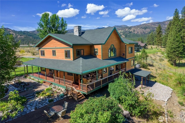 14 Lodge Ln, Winthrop, WA 98862 - rear view of property with roof with shingles, a mountain view, a chimney, central AC unit, and covered porch