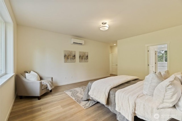 16106 Broadway Ave, Snohomish, WA 98296 - bedroom with a wall mounted AC, light wood-style floors, baseboards, and connected bathroom