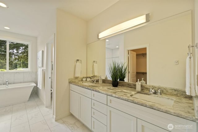 16106 Broadway Ave, Snohomish, WA 98296 - bathroom featuring double vanity, a soaking tub, marble look tile flooring, recessed lighting, and a walk in closet