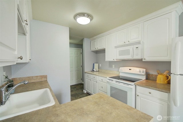 kitchen featuring a sink, light countertops, white appliances, and white cabinetry