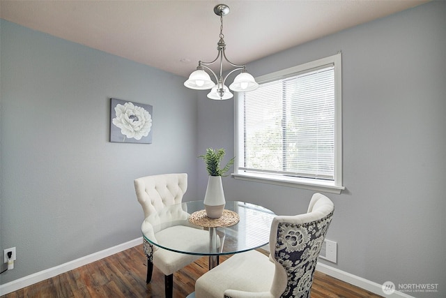 dining area with baseboards, an inviting chandelier, and wood finished floors