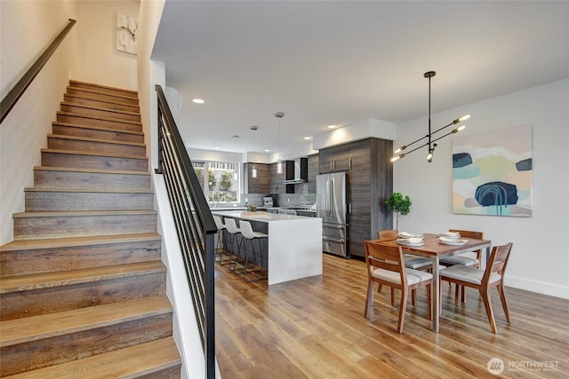 stairway with wood finished floors and recessed lighting