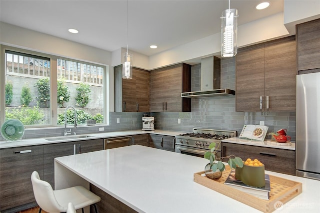 kitchen featuring modern cabinets, a sink, appliances with stainless steel finishes, and wall chimney range hood