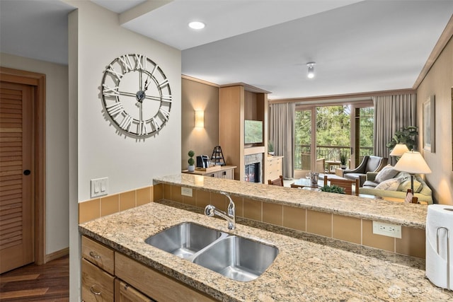 3600 Suncadia Trl Unit 4018, Cle Elum, WA 98922 - kitchen with recessed lighting, a sink, a glass covered fireplace, light stone counters, and wood finished floors