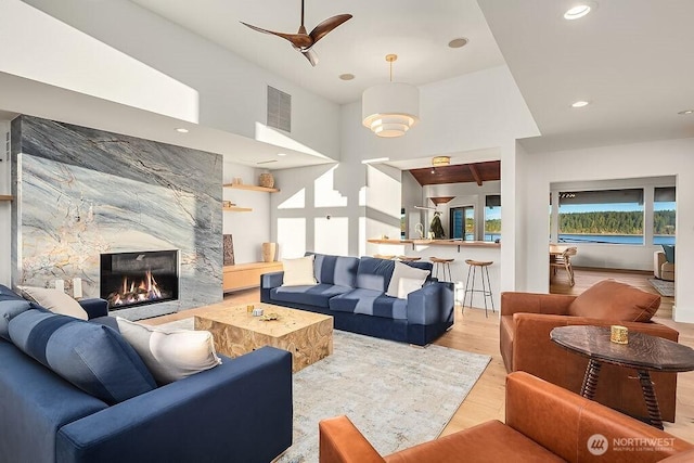 5023 Harbor Hills Dr, Freeland, WA 98249 - living area with recessed lighting, a high ceiling, wood finished floors, visible vents, and a stone fireplace