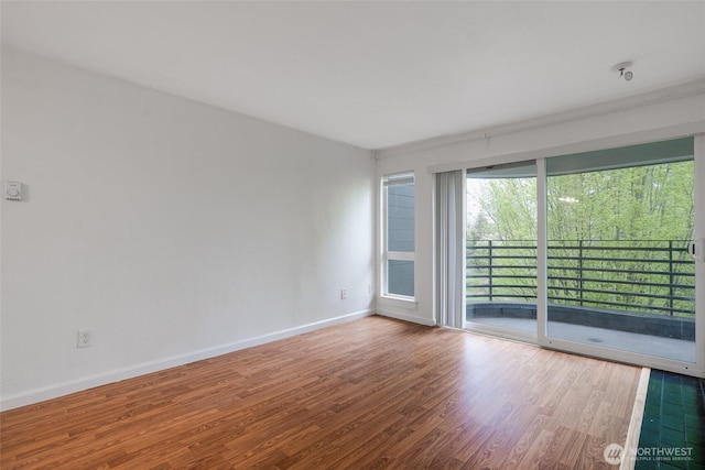 empty room with baseboards and wood finished floors