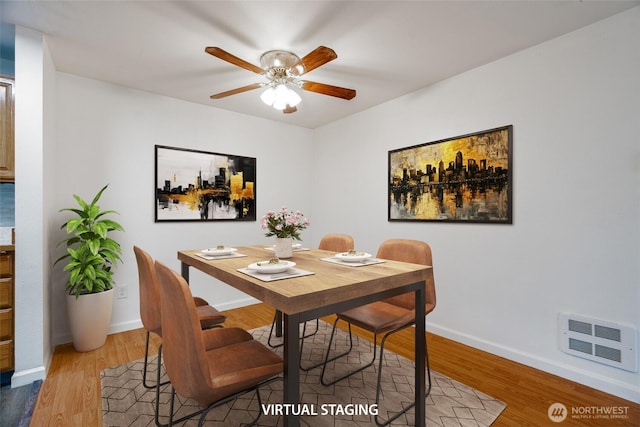 dining space with baseboards, ceiling fan, wood finished floors, and visible vents
