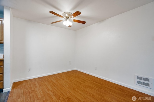 empty room featuring baseboards, ceiling fan, wood finished floors, and visible vents