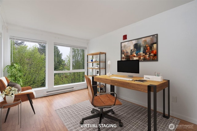 office space featuring baseboards, a baseboard heating unit, and wood finished floors