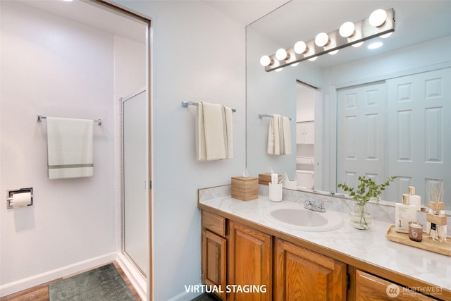 bathroom featuring vanity, baseboards, and a shower stall
