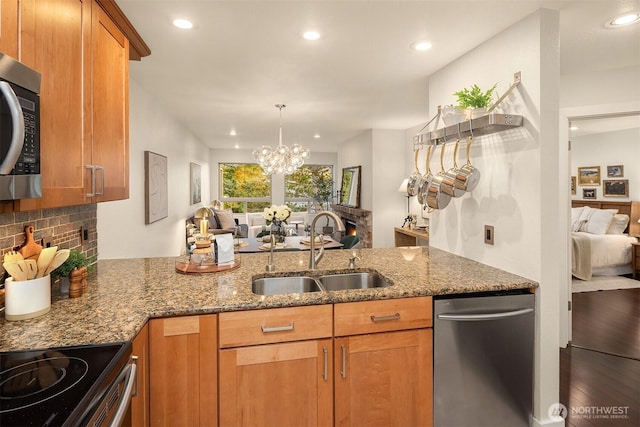 605 5th St Unit B302, Kirkland, WA 98033 - kitchen featuring light stone countertops, a sink, open floor plan, and stainless steel appliances