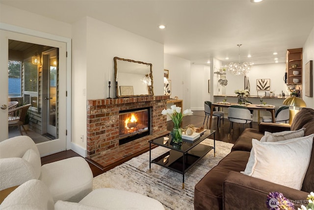 605 5th St Unit B302, Kirkland, WA 98033 - living area with wood finished floors, a fireplace, baseboards, recessed lighting, and a notable chandelier