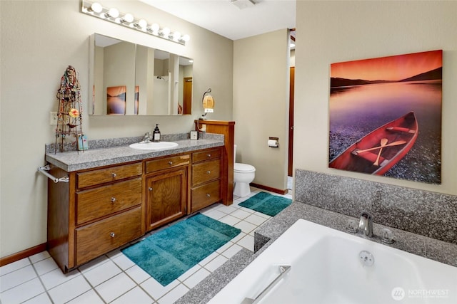 bathroom featuring tile patterned floors, toilet, vanity, a bath, and baseboards