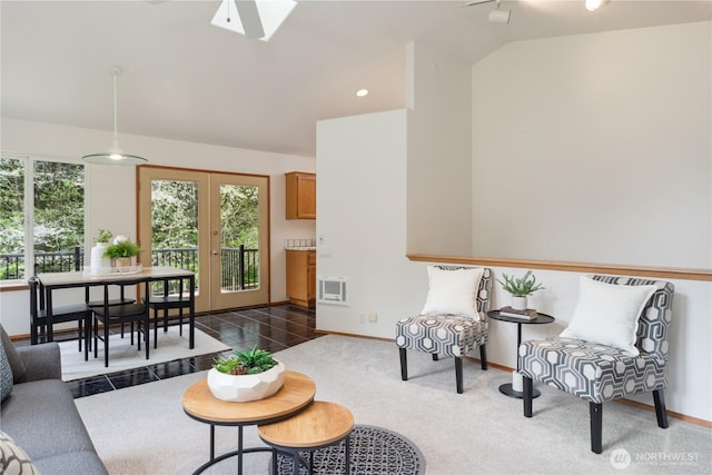 living area with a wealth of natural light, lofted ceiling with skylight, and baseboards