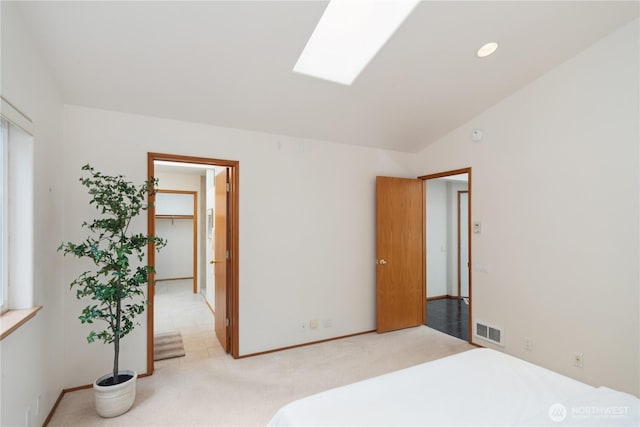 unfurnished bedroom featuring light carpet, baseboards, visible vents, and a spacious closet