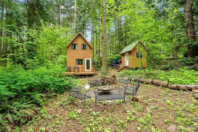 89 Eliza Is, Bellingham, WA 98226 - view of yard featuring a view of trees, an outdoor structure, an outdoor fire pit, and a deck
