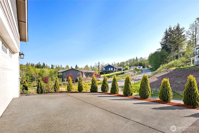 view of patio with a residential view and aphalt driveway
