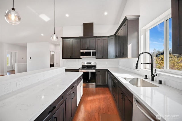 kitchen with a sink, appliances with stainless steel finishes, plenty of natural light, and light stone countertops