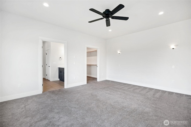 unfurnished bedroom with light colored carpet, recessed lighting, and a spacious closet