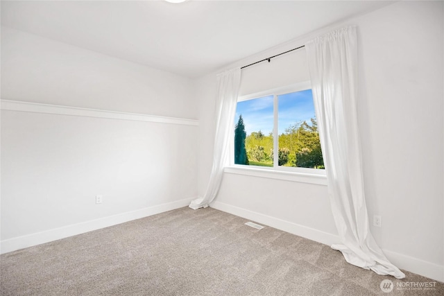 carpeted empty room featuring baseboards and visible vents