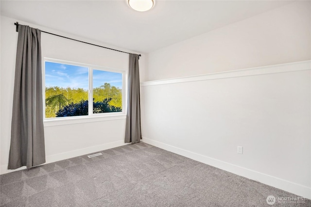 carpeted spare room featuring baseboards and visible vents
