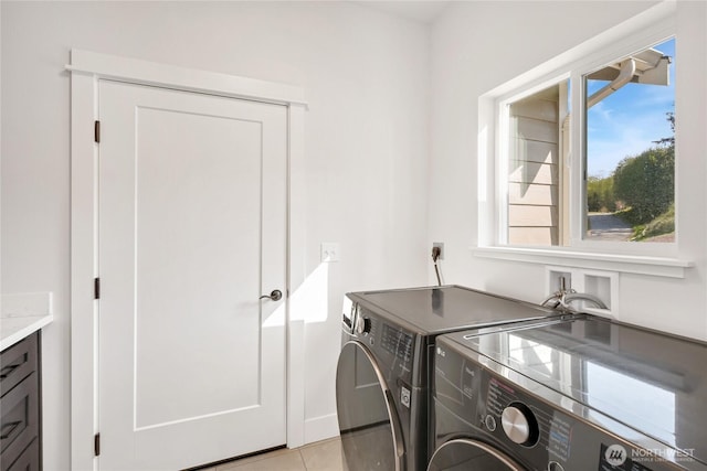 clothes washing area featuring light tile patterned floors, laundry area, and independent washer and dryer