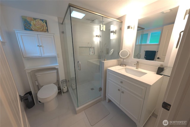 full bathroom featuring toilet, tile patterned floors, a shower stall, and vanity