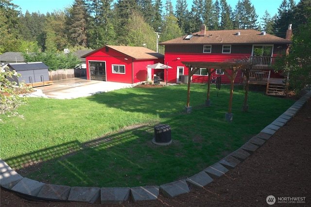 view of yard featuring an outbuilding, a wooden deck, fence, cooling unit, and a patio
